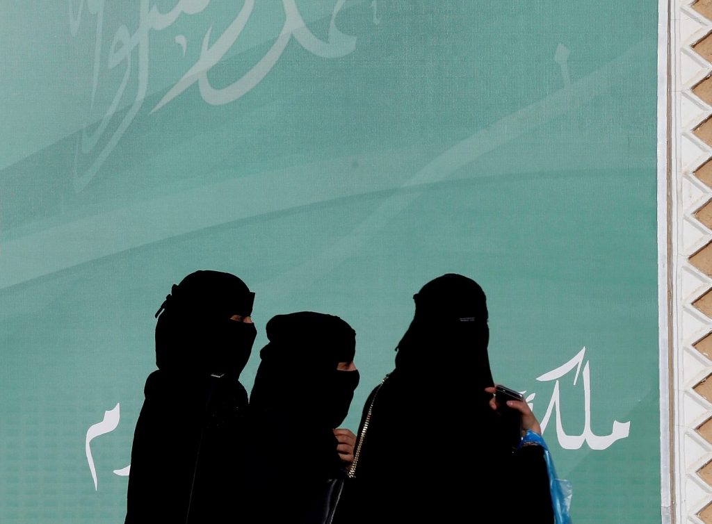 File photo of women walk past a poster on the outskirts of Riyadh, Saudi Arabia February 12, 2018. REUTERS/Faisal Al Nasser/File Photo