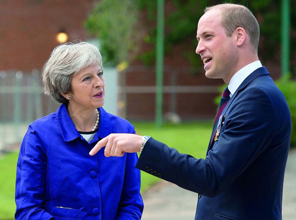 Britain's Prime Minister Theresa May talks with Britain's Prince William during the official handover to the nation of the newly built Defence and National Rehabilitation Centre (DNRC) at the Stanford Hall Estate, Loughborough, Britain, June 21, 2018. Oli