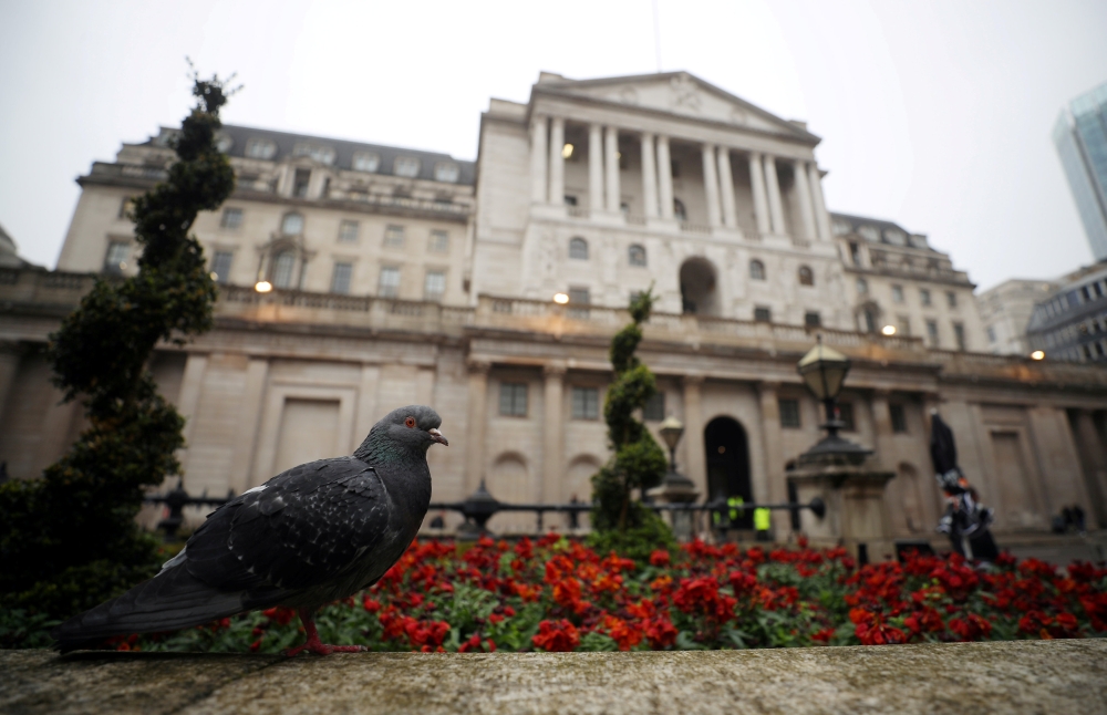 FILE PHOTO: A pigeon stands in front of the Bank of England in London, Britain, April 9, 2018. REUTERS/Hannah McKay/File Photo