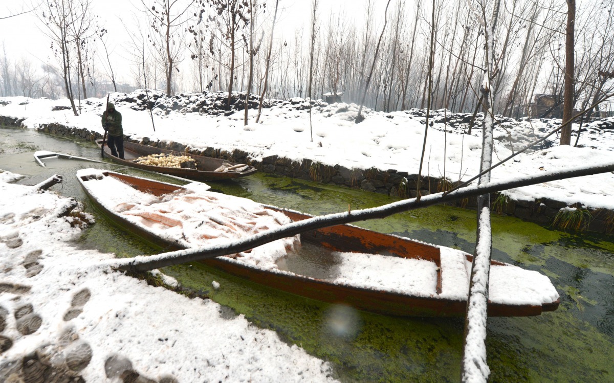 A Kashmiri farmer rows his boat on the Dal Lake during a heavy snowfall in Srinagar on January 25, 2017. (AFP / Tauseef Mustafa) 