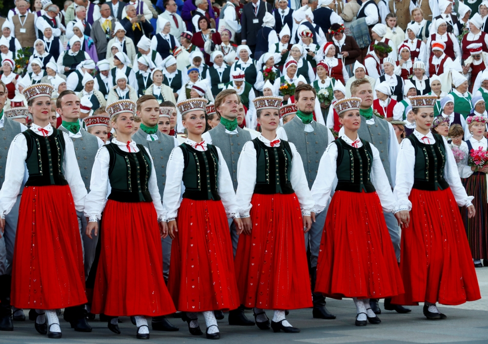 Choir singers and dancers wear traditional dress as they perform during the final show at the Song and Dance Celebration in Riga, Latvia July 8, 2018. Reuters/Ints Kalnins

