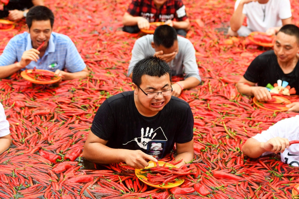 This photo taken on July 8, 2018 shows a contestant taking part in a chilli pepper-eating competition in Ningxiang in China's central Hunan province. The winner of the contest ate 50 chilli peppers in one minute. - China OUT / AFP 