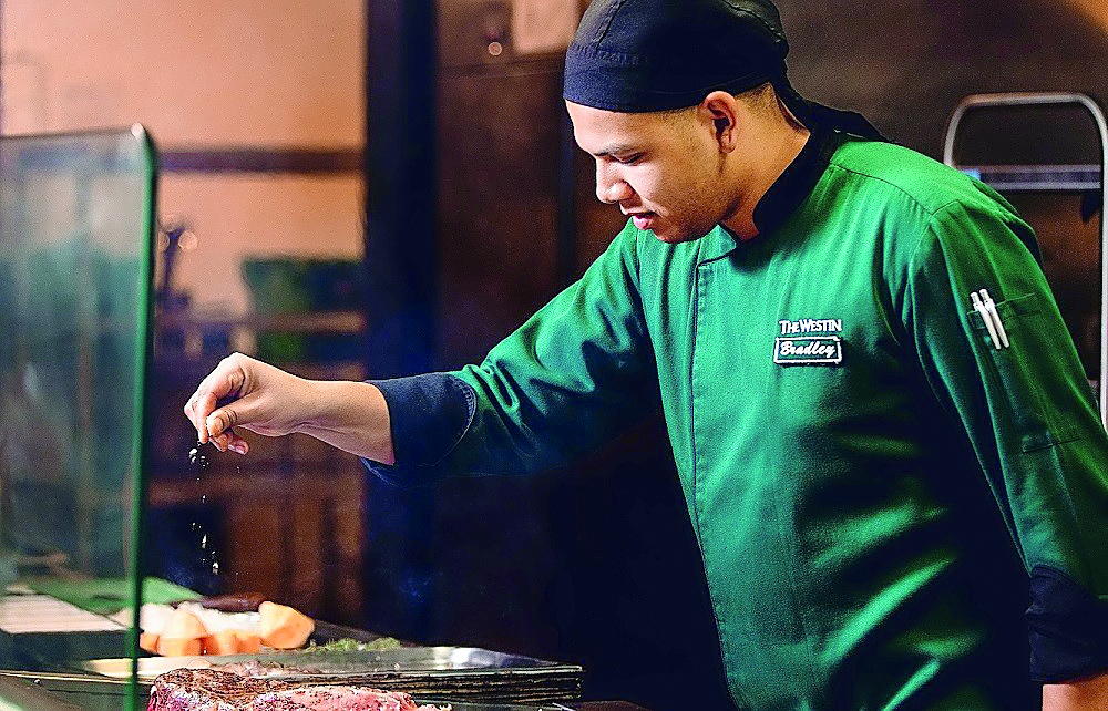 Chef Bradley Mathias cooking a dish at Hunters Room & Grill at The Westin Doha  Hotel and Spa. 