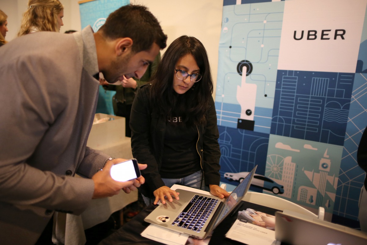 FILE PHOTO: Uber recruiter Lorena Castellanos, 26,  talks to jobseeker Masood Noori, 26, at TechFair LA a technology job fair in Los Angeles.  Reuters/Lucy Nicholson