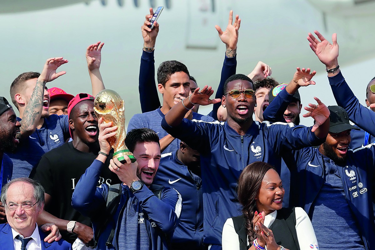 French goalkeeper Hugo Lloris holds the trophy as he celebrates with team-mates and icials upon their arrival at the Roissy-Charles de Gaulle airport in Paris yesterday, after winning the FIFA 2018 World Cup final.