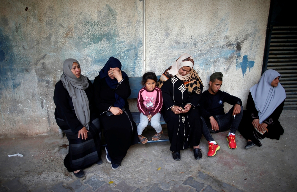 REPRESENTATIVE IMAGE: A Palestinian woman sits with a child after receiving food supplies from the UN offices in the Khan Yunis refugee camp in the southern Gaza Strip, on February 11, 2018. (AFP / Said Khatib) 