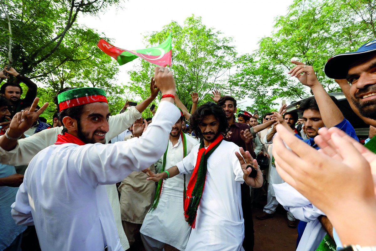 Supporters of cricket star-turned-politician Imran Khan, chairman of Pakistan Tehreek-e-Insaf (PTI), celebrate outside his residence in Islamabad, Pakistan, a day after polling in the general election, July 26, 2018. Reuters/Faisal Mahmood