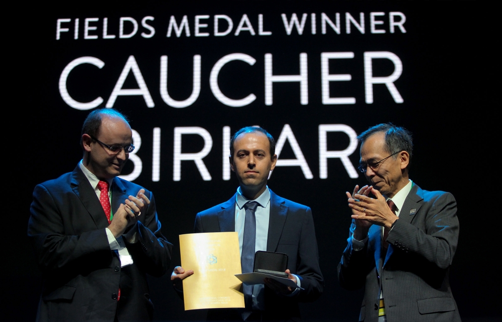 This handout picture released by International Mathematics Convention (ICM 2018) shows the Kurdish mathematician, Cauchar Birkar (C), 40, receiving the Fields Medals Award, math's most prestigious prize, at the International Mathematics Convention (ICM 20