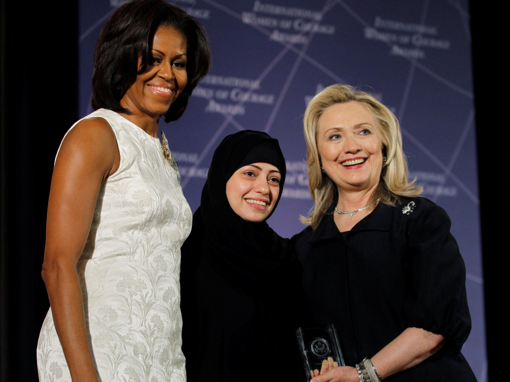 Former US Secretary of State Hillary Clinton and then First lady Michelle Obama congratulate Samar Badawi of Saudi Arabia during the State Department's 2012 International Women of Courage Award winners ceremony in Washington March 8, 2012. (REUTERS/Gary C