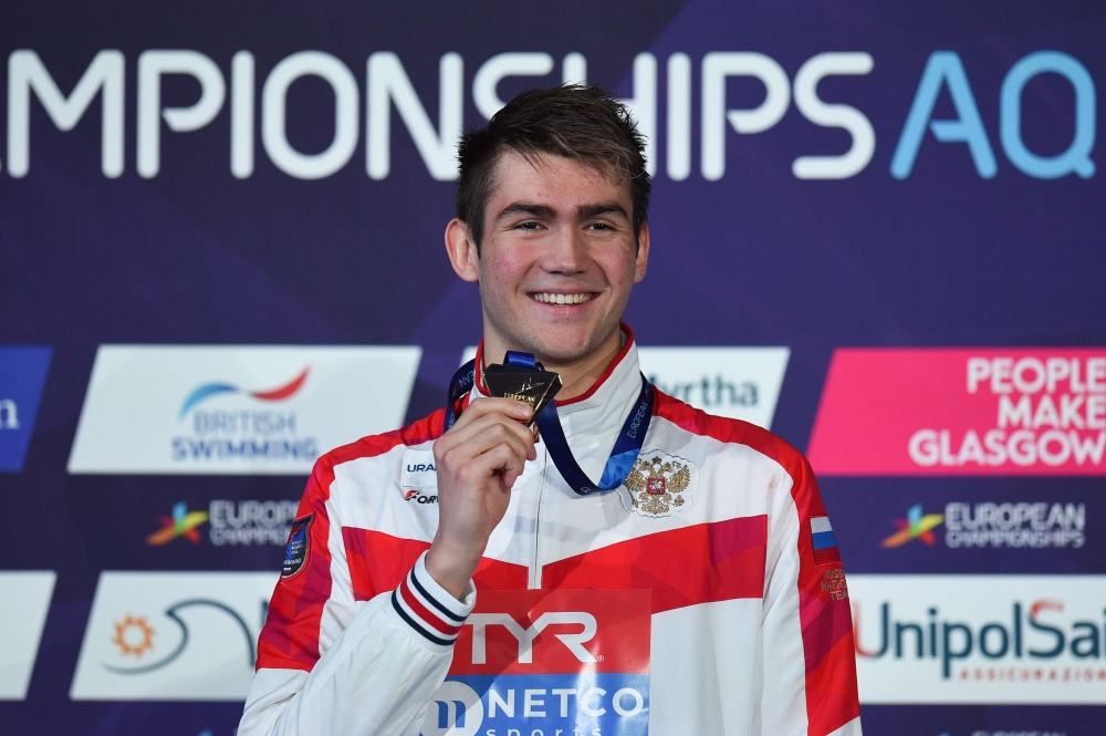 Gold medallist Russia's Kliment Kolesnikov poses on the podium during the medal ceremony for the Men's 50m backstroke swimming final at the Tollcross swimming centre during the 2018 European Championships in Glasgow on August 4, 2018. (AFP / Oli SCARFF)