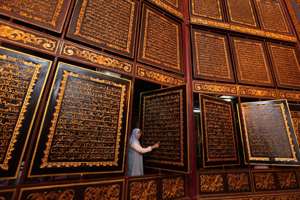 People visit the Bayt Al Quran Al Akbar Museum in Palembang, Indonesia on August 5, 2018. Parts of Holy Quran were beautifully carved on the 1,77 x 1,4 meters wide and 2,5 cm thick Tembesu wood at the 5-storey building. (Muhammad AF/ Anadolu Agency)