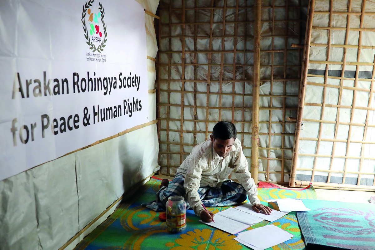 Mohib Bullah, a member of Arakan Rohingya Society for Peace and Human Rights, writes after collecting data about victims of a military crackdown in Myanmar, at Kutupalong camp in Cox's Bazar, Bangladesh, April 21, 2018.  Reuters/Mohammad Ponir Hossain 