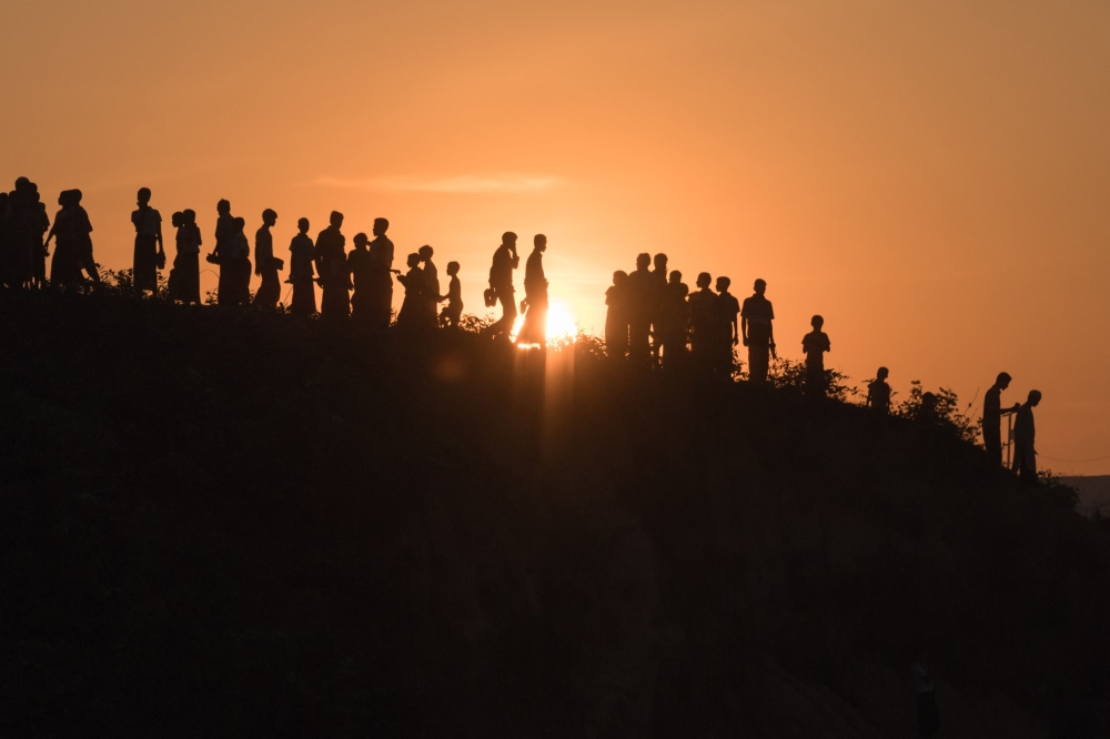 In this file photo taken on November 26, 2017 Rohingya Muslim refugees walk down a hillside in the Kutupalong refugee camp in Bangladesh. AFP / Ed Jones 