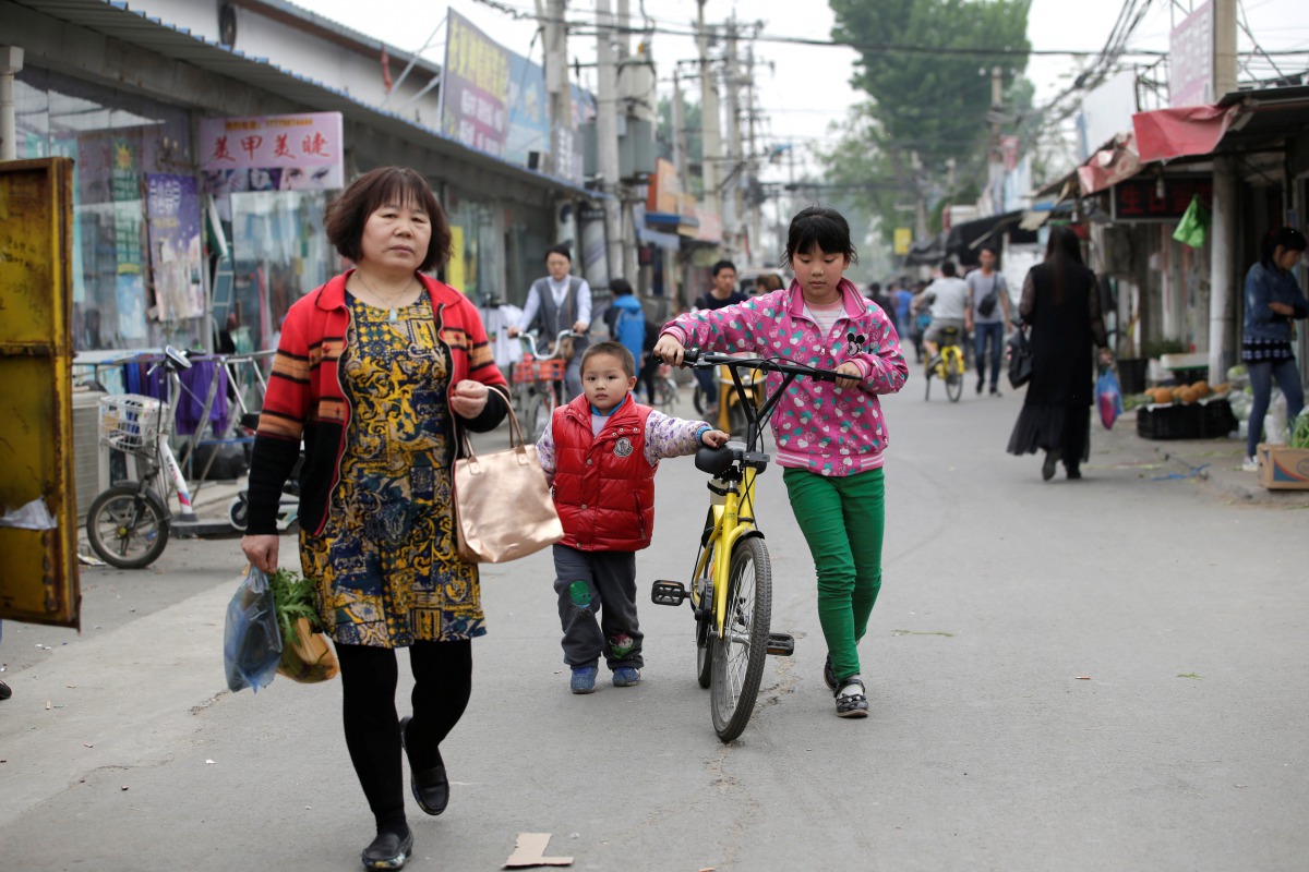 Children use an Ofo shared bike at a residential area for migrant workers in a village on the outskirts of Beijing , April 16, 2017.(Reuters/Jason Lee) 