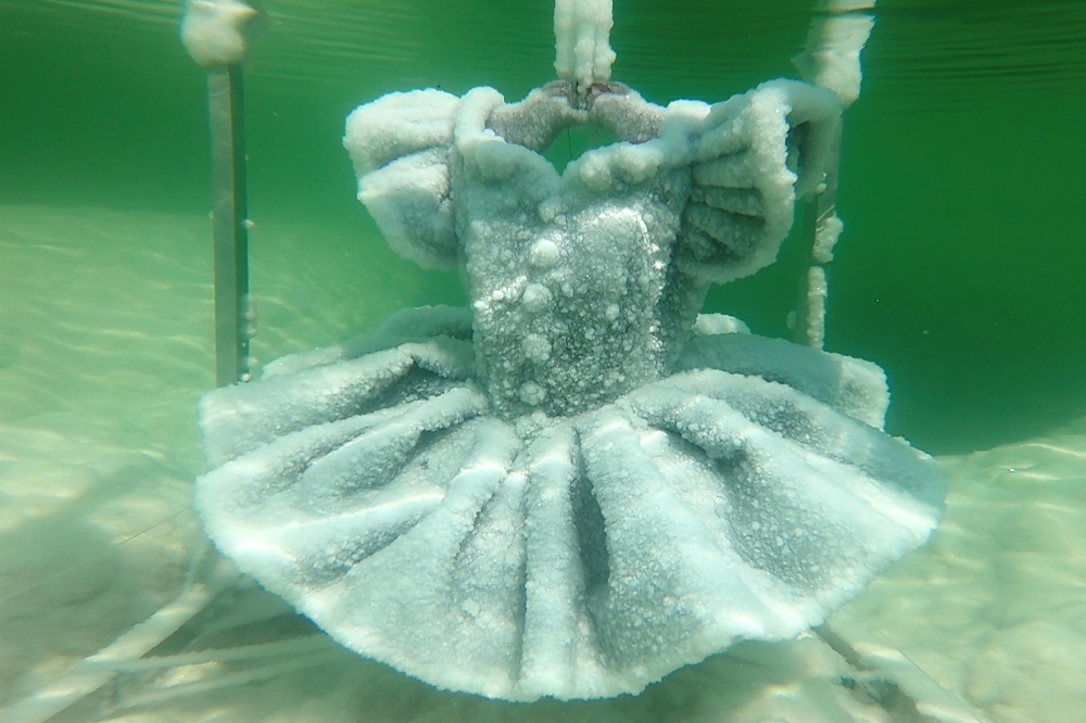 One of Israeli artist Sigalit Landau's pieces, a ballerina's tutu covered in salt crystal formations, is seen submerged in the hyper-saline waters of the Dead Sea, Israel August 30, 2018, in this still image taken from a video. REUTERS TV/ via REUTERS