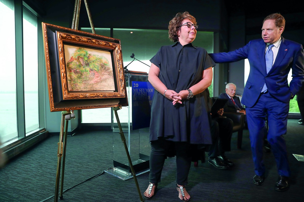 Sylvie Sulitzer stands with Geoffrey S. Berman (L), the United States Attorney for the Southern District of New York after unveiling the painting Deux Femmes Dans Un Jardin by Pierre Auguste Renoir during a ceremony to return the painting, stolen by the N