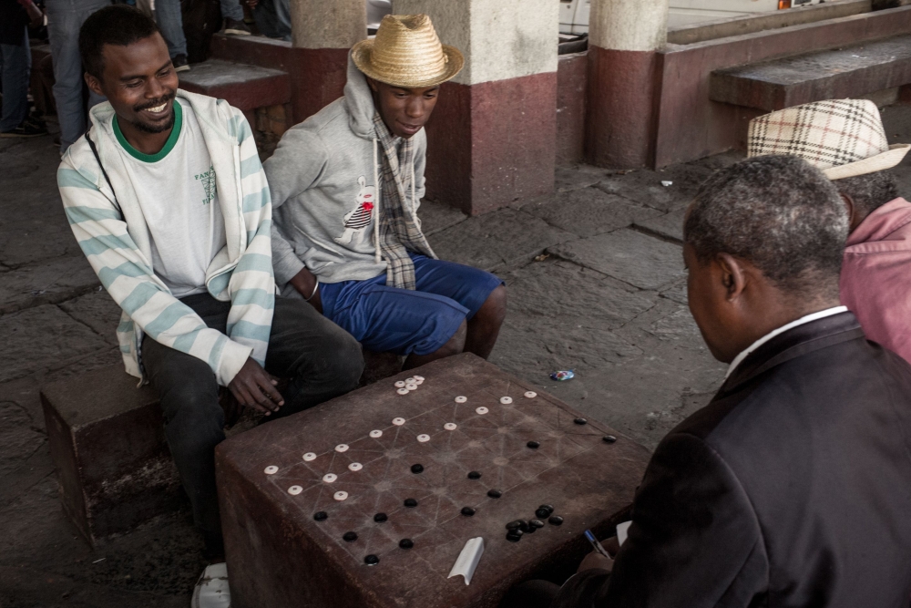 Jean-Marie Andriatsarafara (R), known as Zamabe, 30-years-old, a player of Fanorona since the age of 11 years and champion of Madagascar since 2016, plays a game of Fanorona in the capital Antananarivo on June 20, 2018.  AFP / RIJASOLO