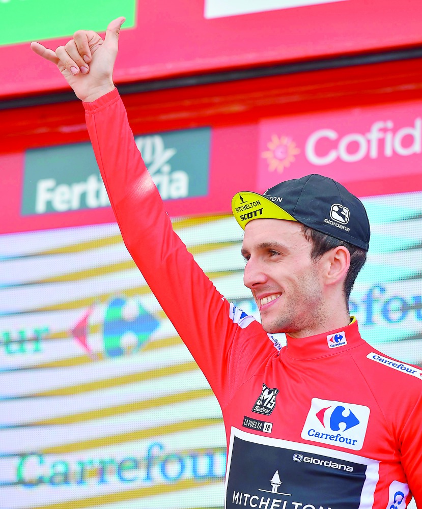 Mitchelton-Scott's British cyclist Simon Philip Yates celebrates on the podium retaining the general rank leader's Red Jersey after the 19th stage of the 73rd edition of 