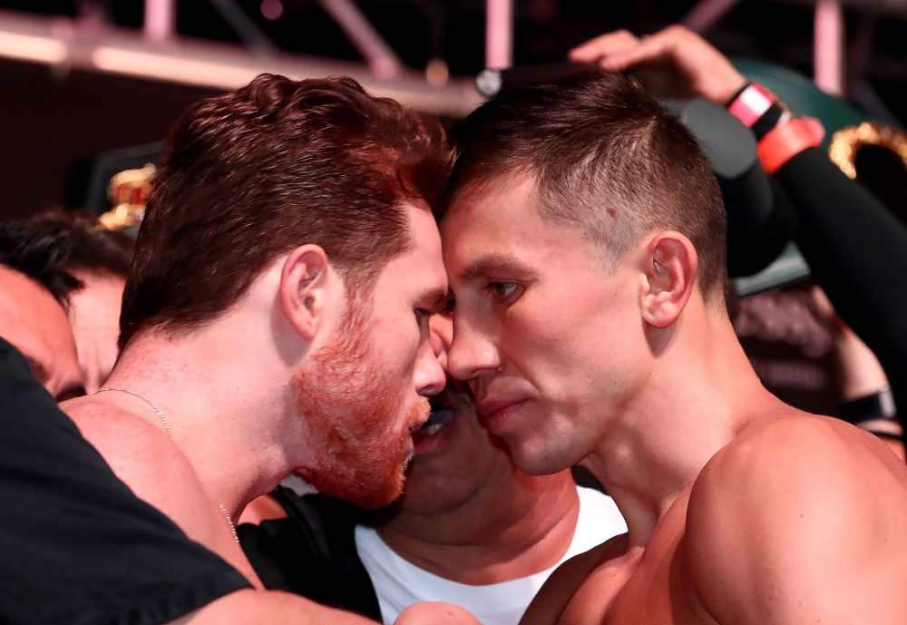 In this file photo taken on September 14, 2018 pro boxer Canelo Alvarez (L) and WBC/WBA middleweight champion Gennady Golovkin are held back after facing off during their official weigh-in at T-Mobile Arena in Las Vegas, Nevada. / AFP / GETTY IMAGES NORTH