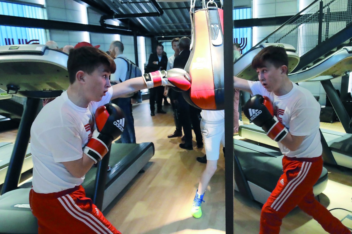 A young boxer is reflected in a mirror as he trains with a punching bag at the re-opening of the Dale Youth Amateur Boxing Club, which was gutted in the 2017 Grenfell Tower fire that killed 71 people, in west London on September 28, 2018. AFP / Tolga Akme