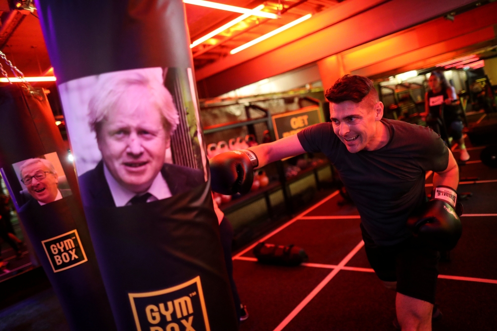 A gym member punches a boxing bag containing an image of Britain's former Foreign Secretary Boris Johnson during a Brexfit gym class at Gym Box in London, Britain September 27, 2018. Picture taken September 27, 2018. REUTERS/Simon Dawson