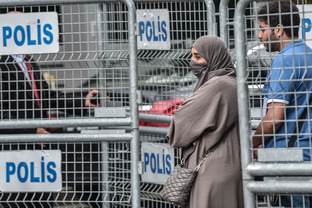 A Saudi Arabian couple stand beside barriers in front of Saudi Arabia's consulate in Istanbul on October 4, 2018.  AFP / Ozan Kose 