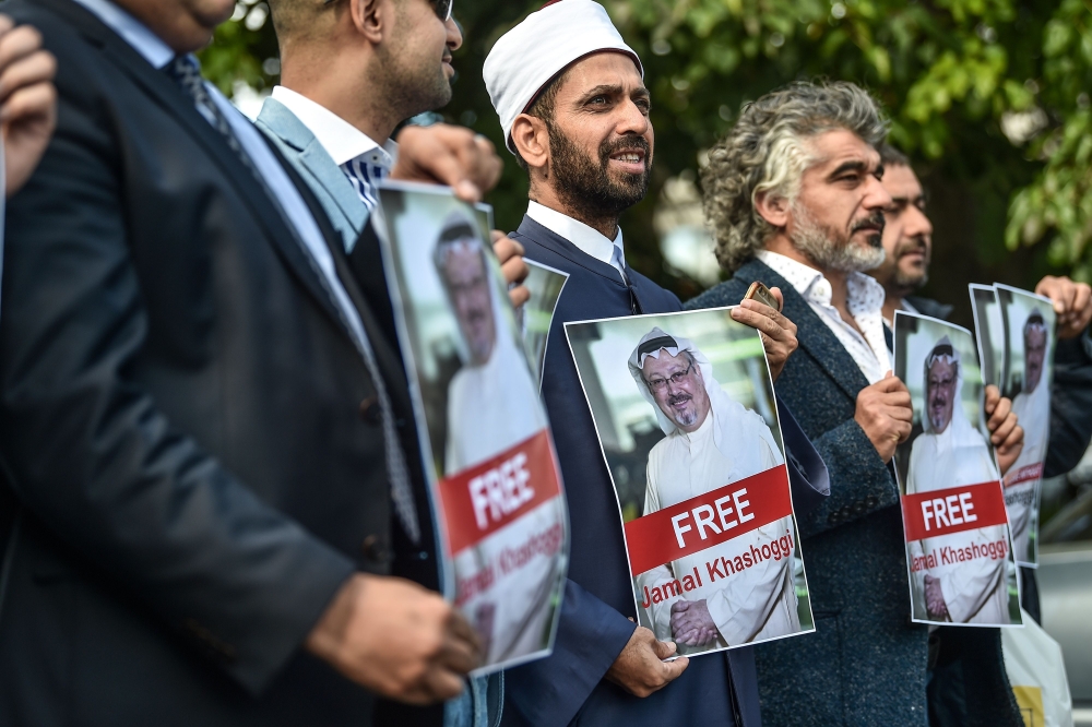 Protestors hold pictures of missing journalist Jamal Khashoggi during a demonstration in front of the Saudi Arabian consulate, on October 5, 2018 in Istanbul.  AFP / Ozan Kose 