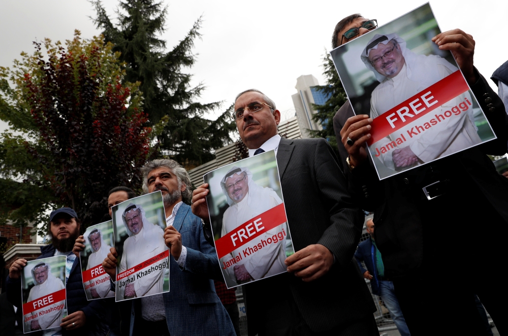 Human rights activists and friends of Saudi journalist Jamal Khashoggi hold his pictures during a protest outside the Saudi Consulate in Istanbul, Turkey October 8, 2018. (REUTERS/Murad Sezer)