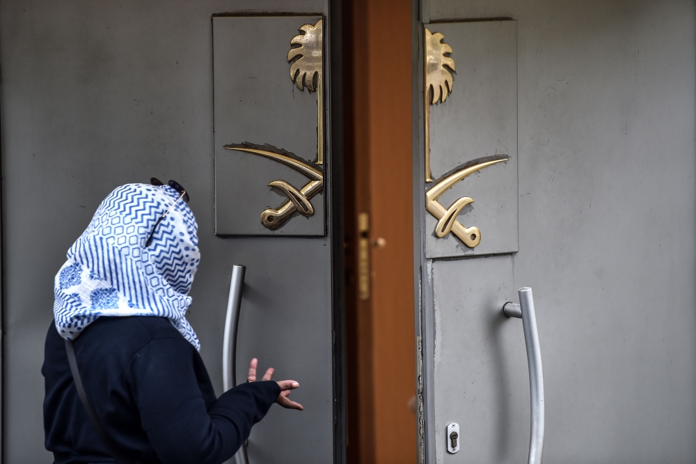 A Saudi citizen stands at the entrance of the Saudi Arabian Consulate as she speaks to a person inside on October 17, 2018 in Istanbul.  AFP / OZAN KOSE