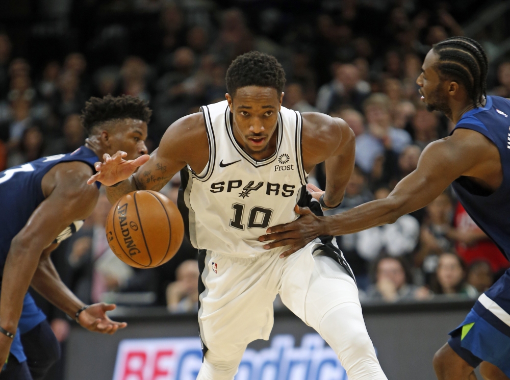 DeMar DeRozan #10 of the San Antonio Spurs is fouled by Andrew Wiggins #22 of the Minnesota Timberwolves in closing seconds in season opener at AT&T Center on October 17 , 2018 in San Antonio, Texas.   Ronald Cortes//AFP