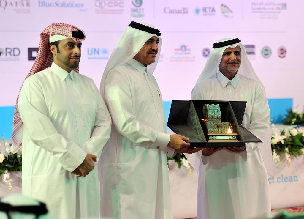 Minister of Municipality and Environment H E Mohammed bin Abdullah Al Rumaihi receiving a memento from Dr Yousef Alhorr, Founder Chairman GORD, Qatar (right) at the Sustainability Summit in Ritz Carlton Doha yesterday. Pic: Abdul Basit / The Peninsula 