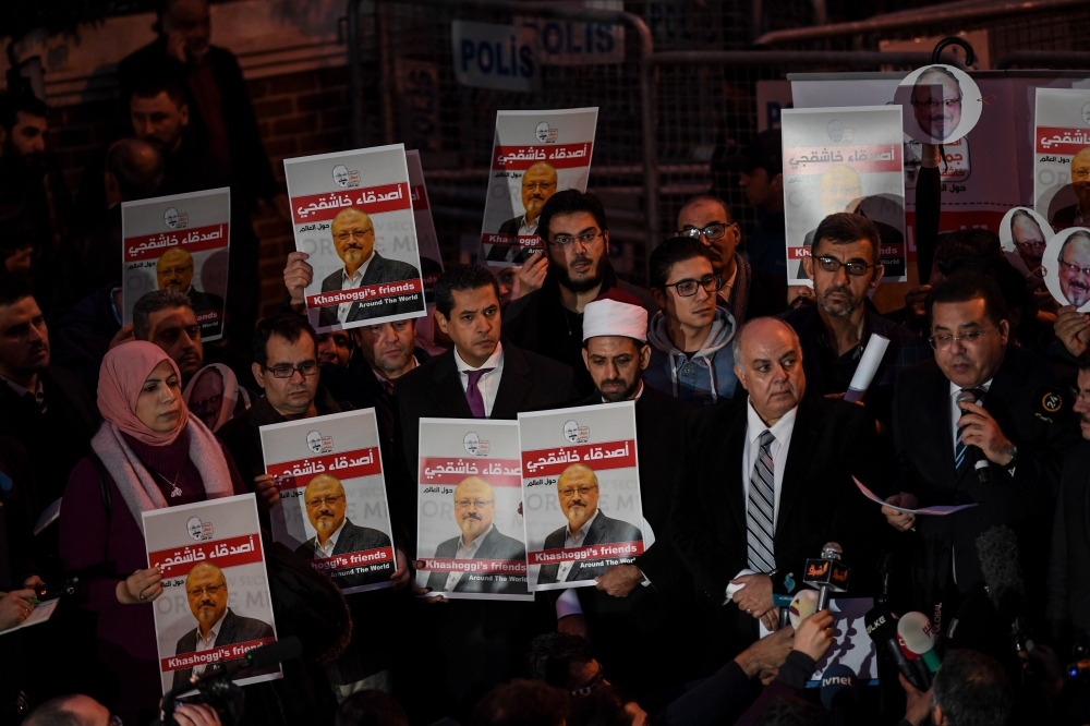 People hold posters picturing Saudi journalist Jamal Khashoggi as they gather outside the Saudi Arabia consulate in Istanbul, on October 25, 2018 during a demonstration. Jamal Khashoggi, a Washington Post contributor, was killed on October 2, 2018 after a