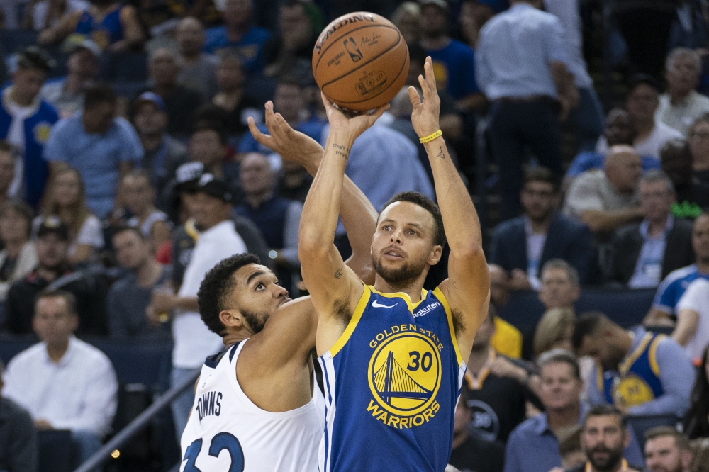 Golden State Warriors guard Stephen Curry (30) shoots the basketball against Minnesota Timberwolves centre Karl-Anthony Towns (32) during the fourth quarter at Oracle Arena. Kyle Terada 