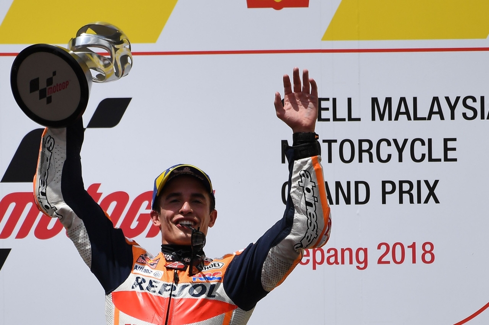 Repsol Honda Team Spanish rider Marc Marquez celebrates on the podium with the trophy after winning the Malaysia MotoGP at the Sepang International Circuit in Sepang on November 4, 2018. / AFP / Mohd RASFAN 