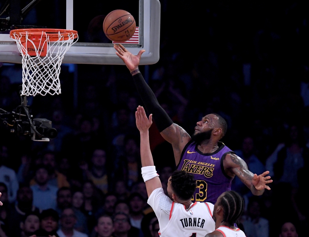 LeBron James #23 of the Los Angeles Lakers scores over Evan Turner #1 of the Portland Trail Blazers during a 126-117 Laker win at Staples Center on November 14, 2018 in Los Angeles, California. Harry How/AFP 