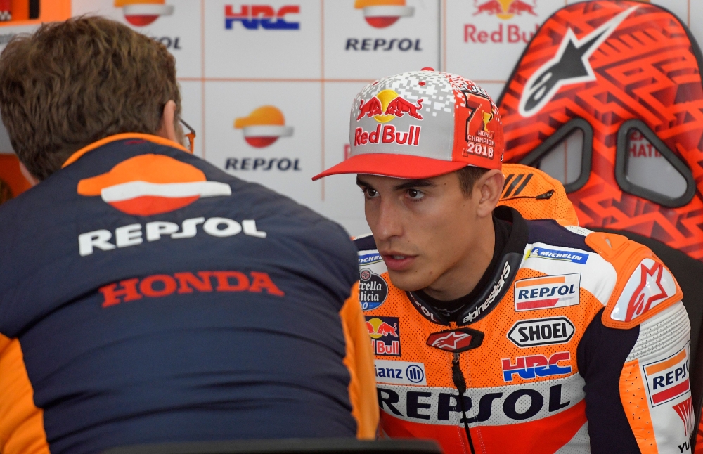 Repsol Honda's Spanish rider Marc Marquez speaks with a mechanic in the box during the fourth MotoGP free practice session of the Valencia Grand Prix at the Ricardo Tormo racetrack in Cheste on November 17, 2018. / AFP / JOSE JORDAN