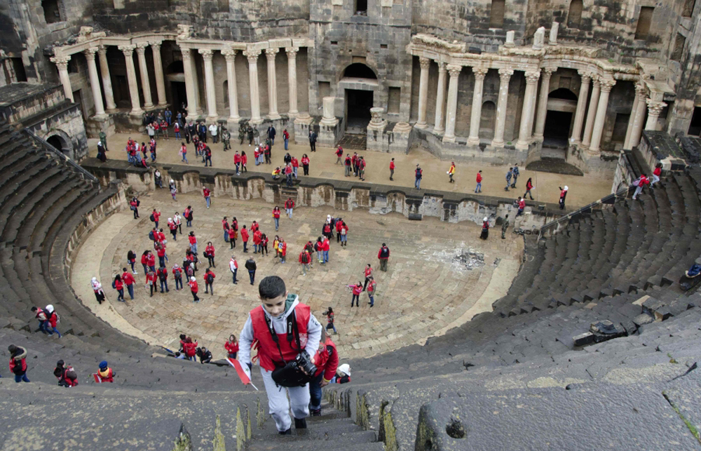 Syrian scouts tour the Roman Theatre at Bosra, a World Heritage Site, south of Sweida, in the Daraa province on November 23, 2018. / AFP / Maher AL MOUNES