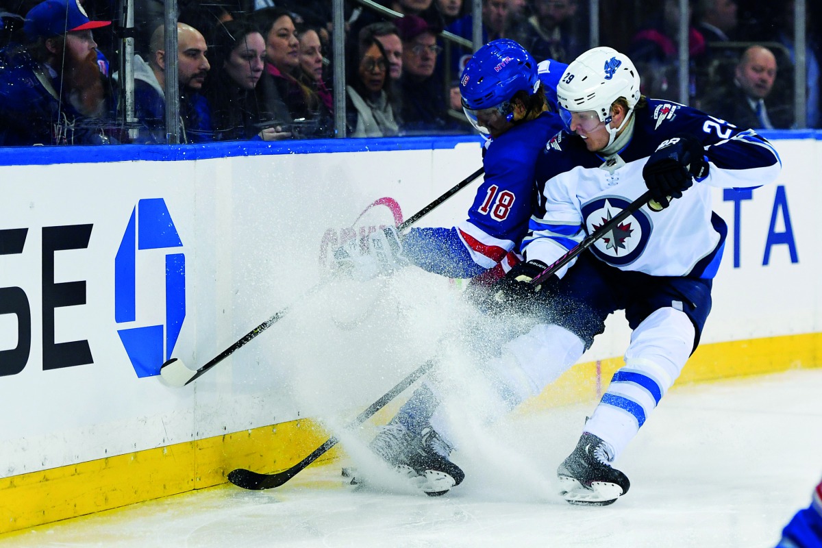 Winnipeg Jets right wing Patrik Laine (29) and New York Rangers defenseman Marc Staal (18) battle for the puck behind the goal during the third period at Madison Square Garden. Credit: Dennis Schneidler-USA Today Sports 