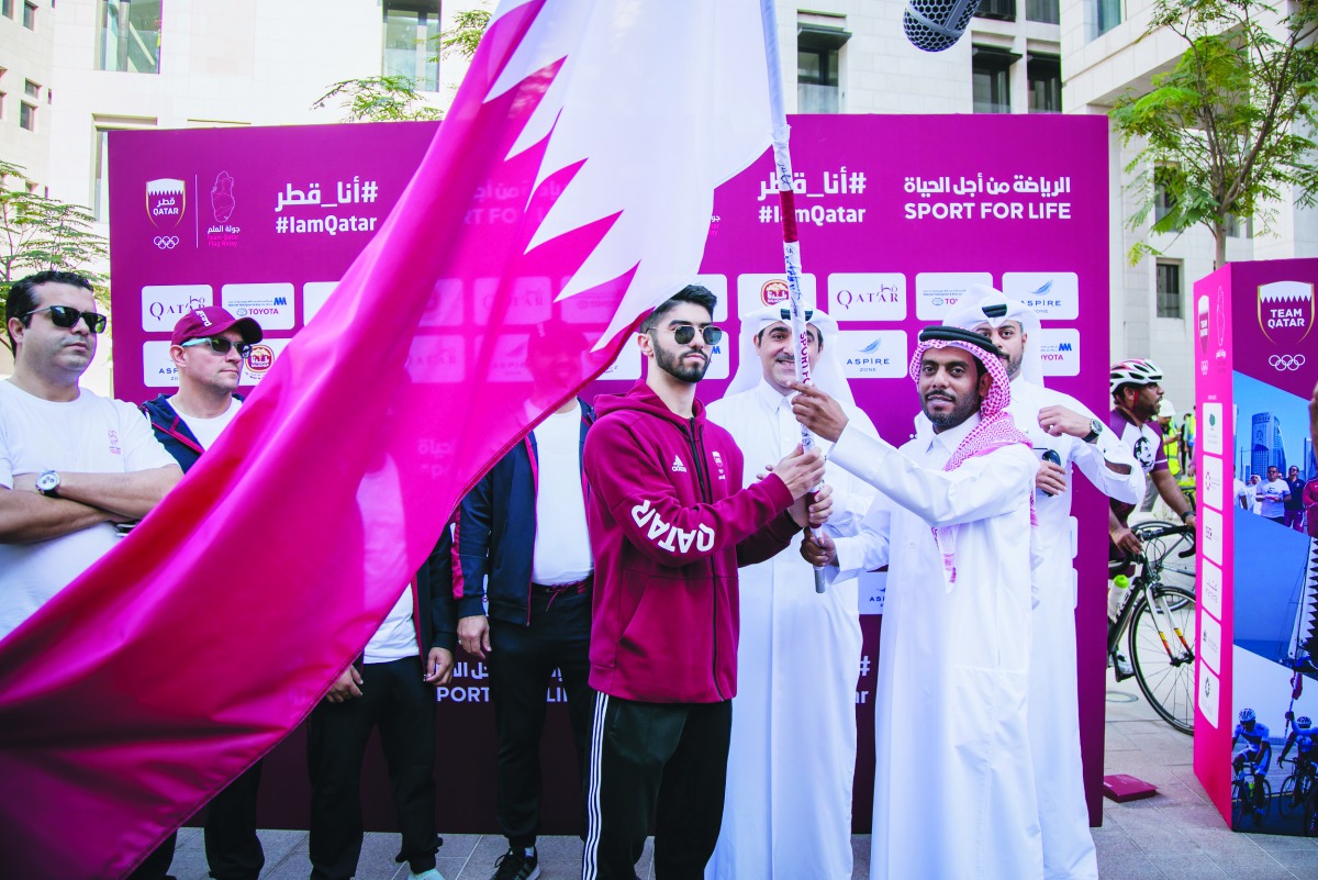 The officials of Msheireb Properties wave Qatari flag as part of the National Day celebrations at Msheireb Downtown Doha. 