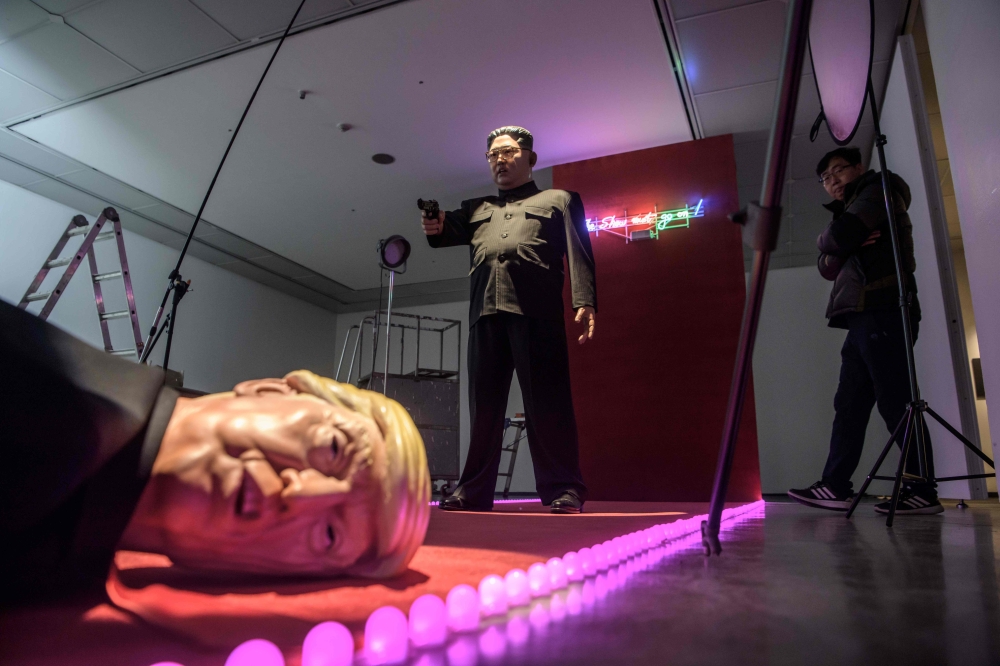 A visitor looks at an art installation by South Korean artist Lim Young-sun entitled 'The Show Must Go On' depicting North Korean leader Kim Jong Un and US president Donald Trump, at the Seoul Art Center on December 19, 2018. AFP / Ed JONES / 