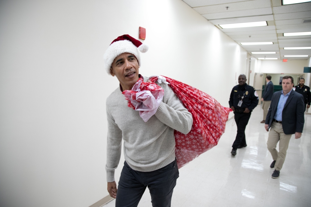 This photograph, obtained courtesy of the Obama Foundation, shows former US President Barack Obama delivering gifts, greeting patients and their parents at Children’s National Medical Center in Washington, DC, December 19, 2018. AFP PHOTO / Courtesy of th