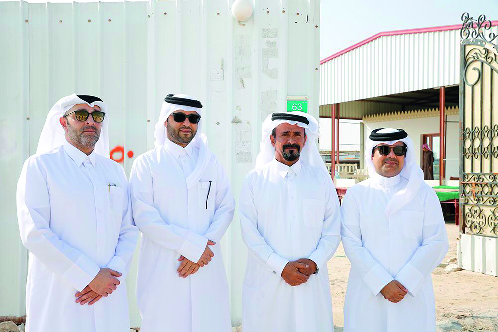 Kahramaa officials with the owner of the first beneficiary farm of electricity posing at the farm after the power connection.  