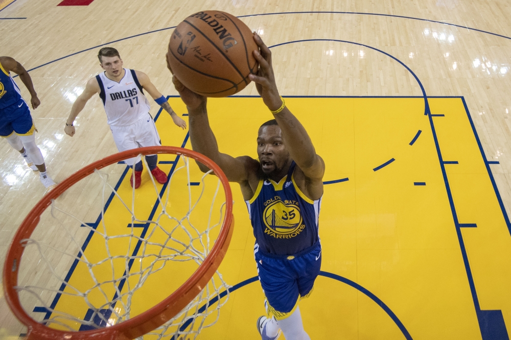 Golden State Warriors forward Kevin Durant (35) dunks the basketball in front of Dallas Mavericks forward Luka Doncic (77) during the first half at Oracle Arena. Kyle Terada