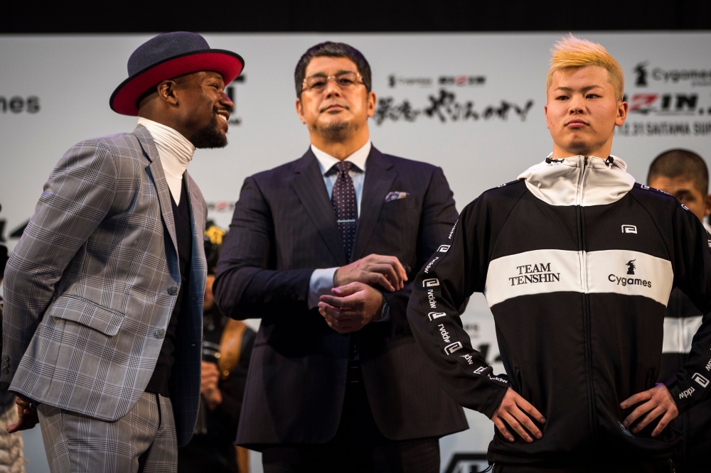 US boxing legend Floyd Mayweather Jr (L) and kickboxer Tenshin Nasukawa of Japan (R) pose on the stage during a weigh-in event at Saitama Super Arena in Saitama on December 30, 2018, on the eve of their exhibition fight. / AFP / Behrouz MEHRI