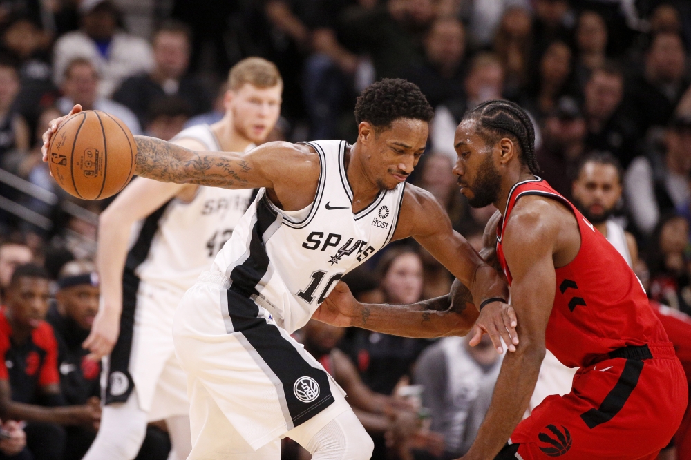  San Antonio Spurs shooting guard DeMar DeRozan (10) dribbles the ball as Toronto Raptors small forward Kawhi Leonard (right) defends during the second half at AT&T Center.  Soobum Im