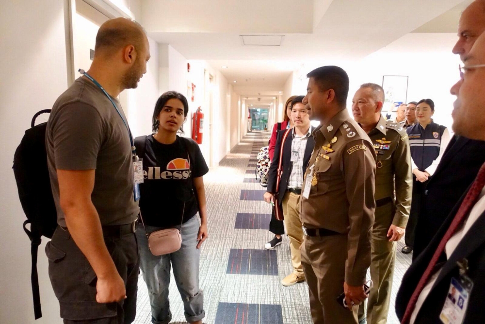 Saudi teen Rahaf Mohammed al-Qunun is greeted by Thai immigration authorities at a hotel inside Suvarnabhumi Airport in Bangkok, Thailand January 7, 2019. Thailand Immigration Police