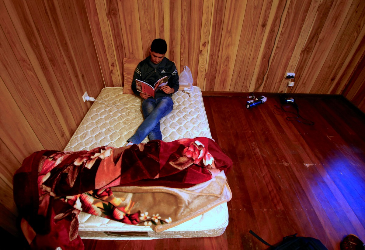 REPRESENTATIVE IMAGE: Ali Rasooli, a refugee from Afghanistan, sits on his mattress reading a book in a house he rents with other refugees in the western Sydney suburb of Guildford, Australia, July 17, 2016. Reuters/David Gray