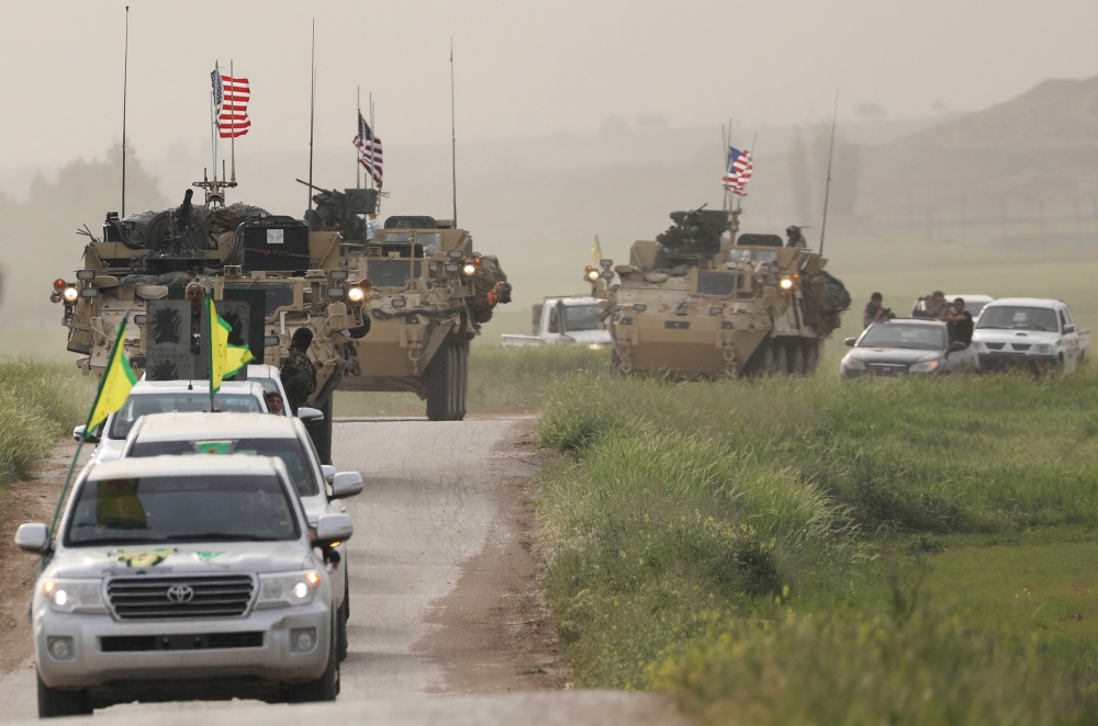 FILE PHOTO: Kurdish fighters from the People's Protection Units (YPG) head a convoy of U.S military vehicles in the town of Darbasiya next to the Turkish border, Syria April 28, 2017. REUTERS/Rodi Said