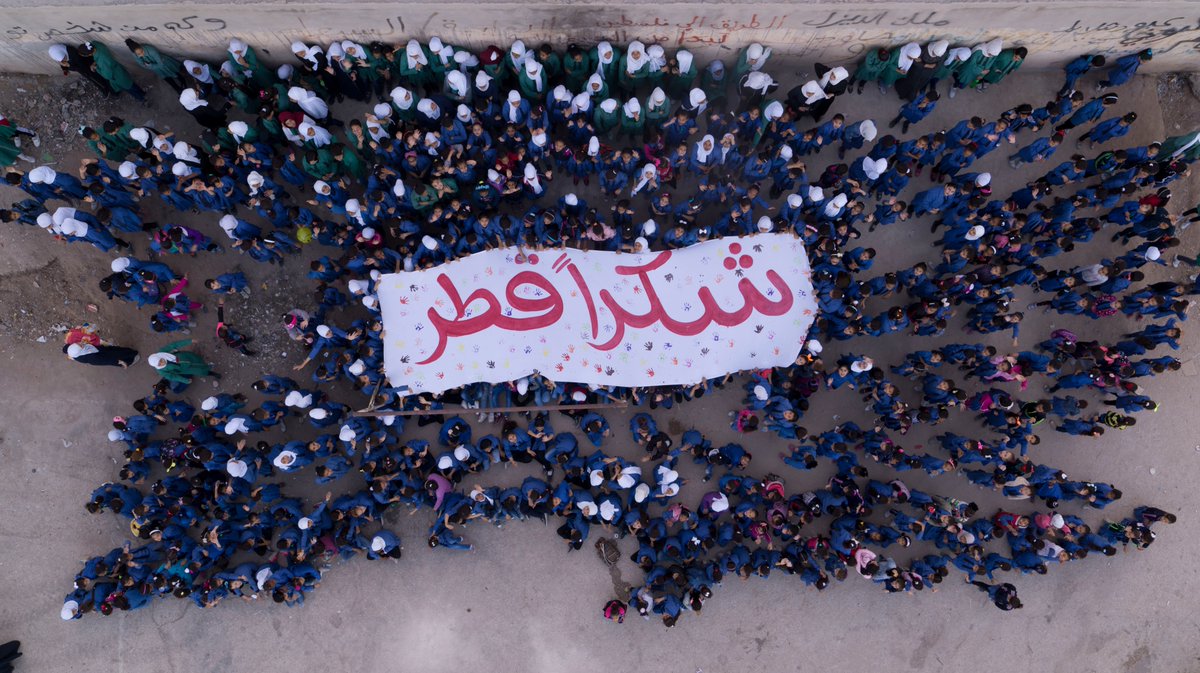 A group of students holding up a banner in Arabic saying “Shukran Qatar” (thank you Qatar). Photo credit: UNRWA