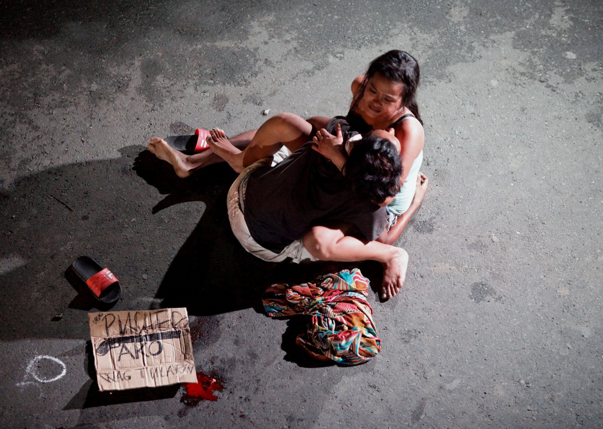 Jennelyn Olaires, 26, cradles the body of her partner who was killed on a street by a vigilante group according to police in a spate of drug related killings in Pasay city, Metro Manila (Reuters/Czar Dancel) 